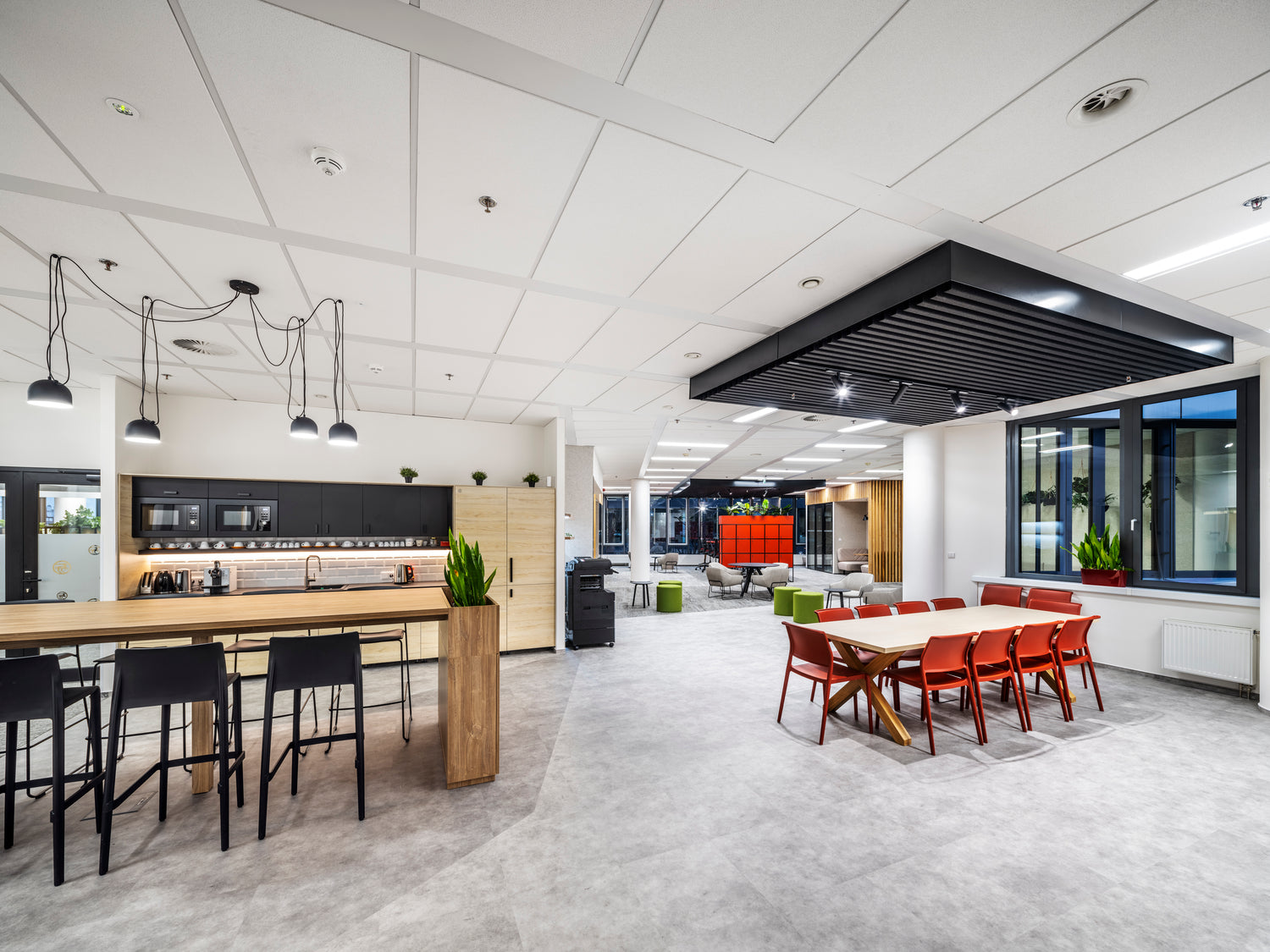 Kuchynská místnost s vysokými stoly a jídelním stolem 